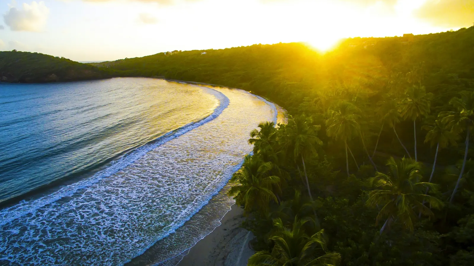 Sunrise over the curved sandy shore and palm forest of La Sagesse Beach in St David, Grenada